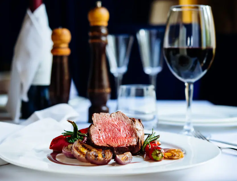 Mesa de restaurante elegante con platos y copas de vino